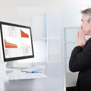 Businessman looking at screen with sales revenue failure results