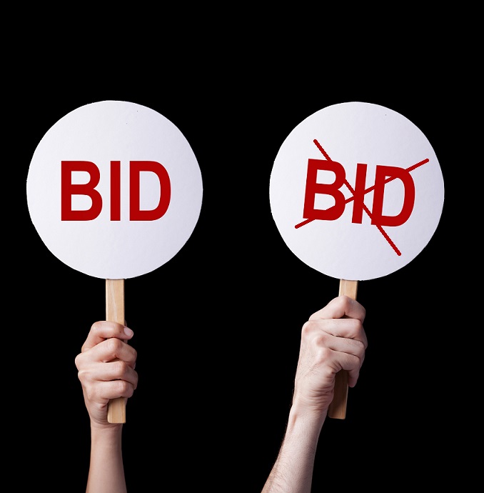 Business Concept of Bidders' hands lifting auction paddlesin a bid or no bid situation